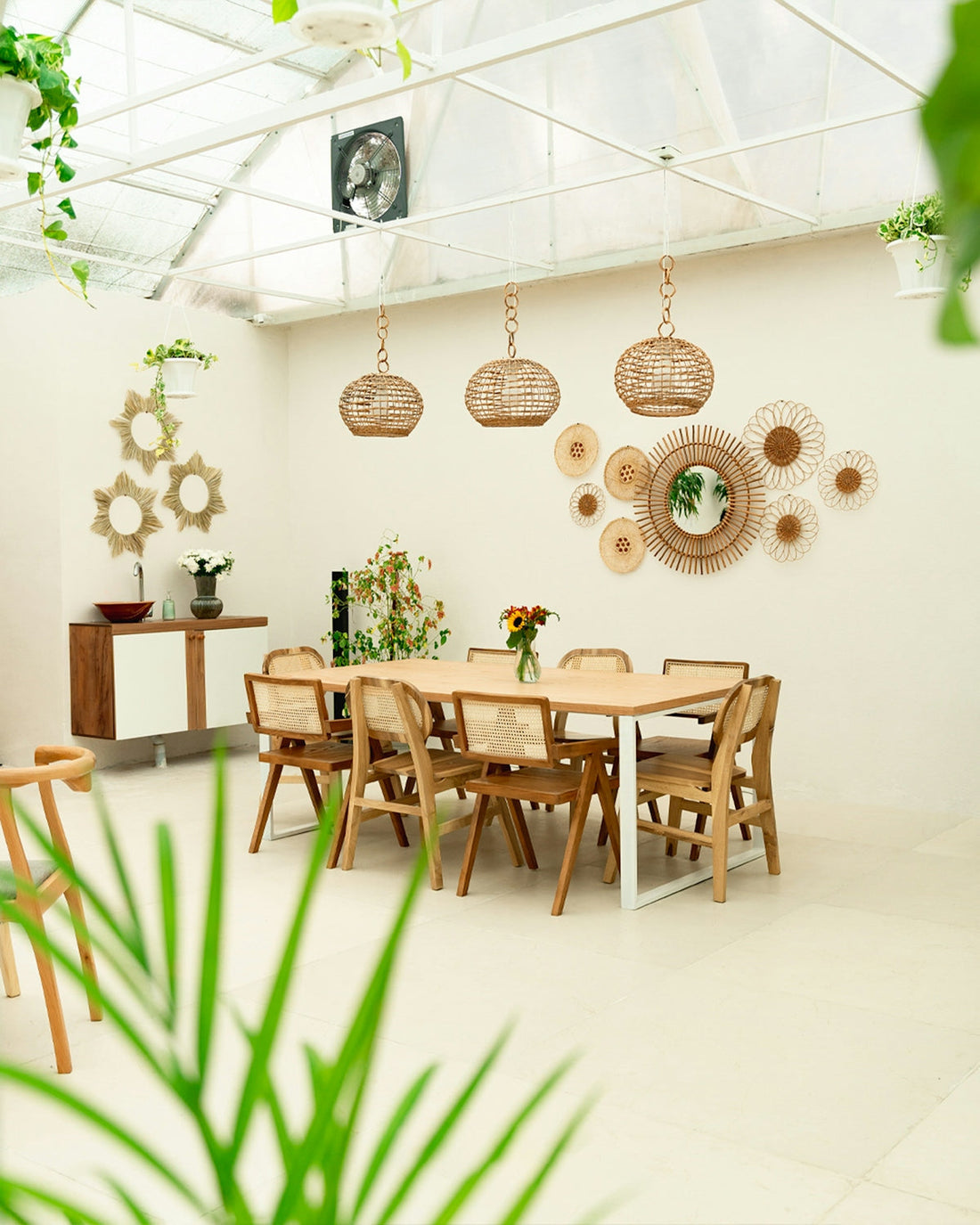 Dining room with wooden table, chairs, and rattan decor.