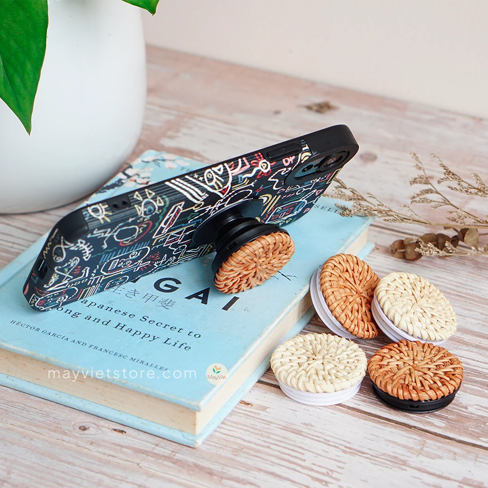 Handwoven rattan phone stand, phone holder, and pop socket in a minimalist design. Perfect for adding a touch of bohemian style to your home or office, or for using on the go.