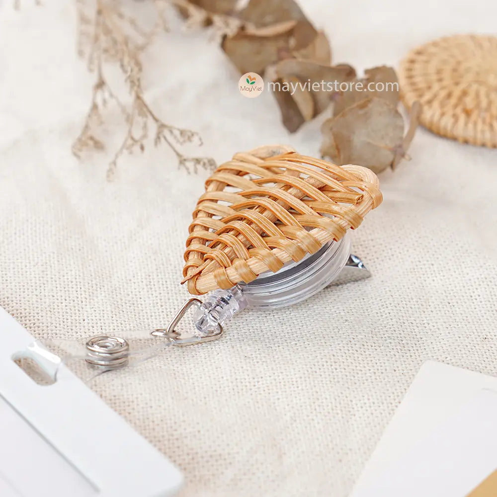 This badge reel clip/card holder is made of rattan. It has a retractable cord and a clip that can be attached to a belt or other clothing. The card holder has three slots for cards, such as a nurse's license and identification card.