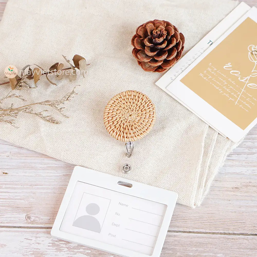 This badge reel clip/card holder is made of rattan. It has a retractable cord and a clip that can be attached to a belt or other clothing. The card holder has three slots for cards, such as a nurse's license and identification card.