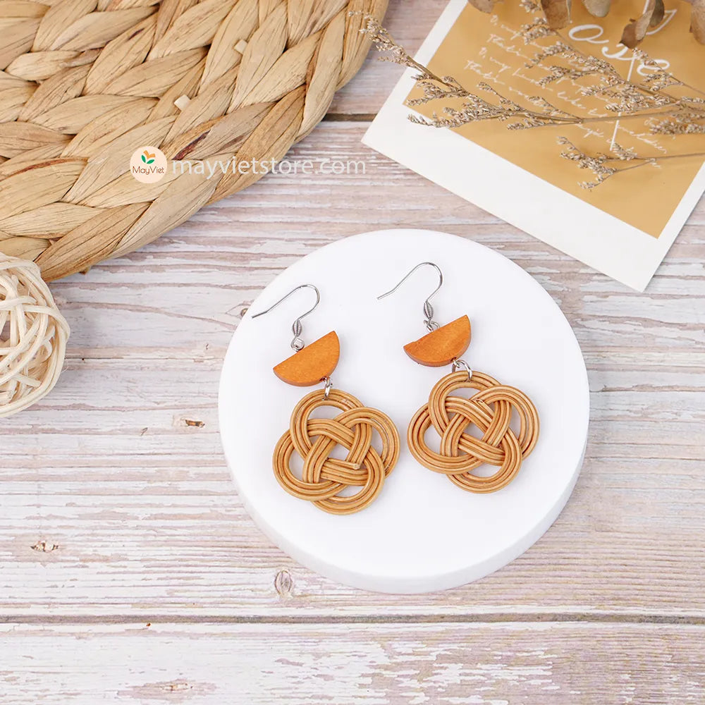 A pair of handcrafted rattan charm earrings with orange wooden beads, made by Mayvietstore. The earrings are made of high-quality rattan and wood, and are lightweight and comfortable to wear. The rattan charms add a touch of fun and personality to the earrings, while the orange wooden beads add a pop of color. These earrings are perfect for any occasion, from a casual day out to a special event.