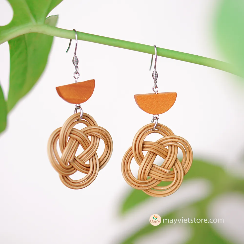 A pair of handcrafted rattan charm earrings with orange wooden beads, made by Mayvietstore. The earrings are made of high-quality rattan and wood, and are lightweight and comfortable to wear. The rattan charms add a touch of fun and personality to the earrings, while the orange wooden beads add a pop of color. These earrings are perfect for any occasion, from a casual day out to a special event.