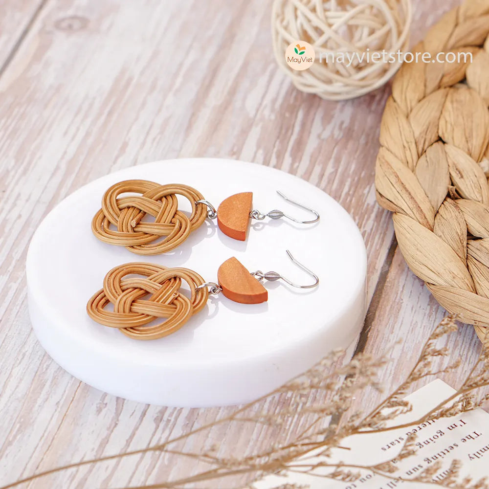 A pair of handcrafted rattan charm earrings with orange wooden beads, made by Mayvietstore. The earrings are made of high-quality rattan and wood, and are lightweight and comfortable to wear. The rattan charms add a touch of fun and personality to the earrings, while the orange wooden beads add a pop of color. These earrings are perfect for any occasion, from a casual day out to a special event.