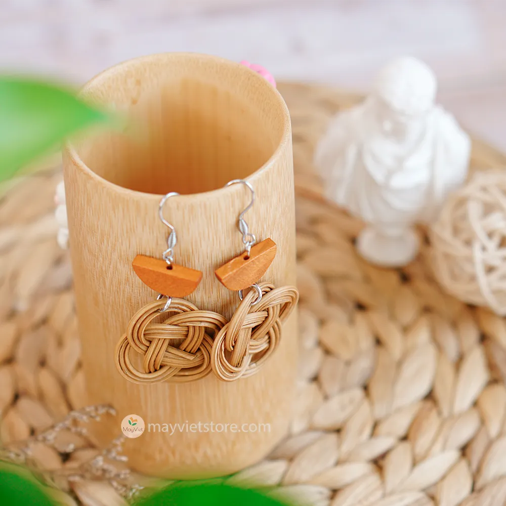 A pair of handcrafted rattan charm earrings with orange wooden beads, made by Mayvietstore. The earrings are made of high-quality rattan and wood, and are lightweight and comfortable to wear. The rattan charms add a touch of fun and personality to the earrings, while the orange wooden beads add a pop of color. These earrings are perfect for any occasion, from a casual day out to a special event.