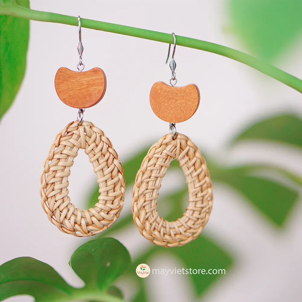 A pair of handcrafted rattan earrings with teardrop-shaped orange wooden beads, made by Mayvietstore. The earrings are made of high-quality rattan and wood, and are lightweight and comfortable to wear. The teardrop-shaped beads add a touch of elegance and sophistication to the earrings, while the rattan gives them a natural and earthy feel. The orange wooden beads add a pop of color and make the earrings stand out. These earrings are perfect for any occasion, from a casual day out to a special event.