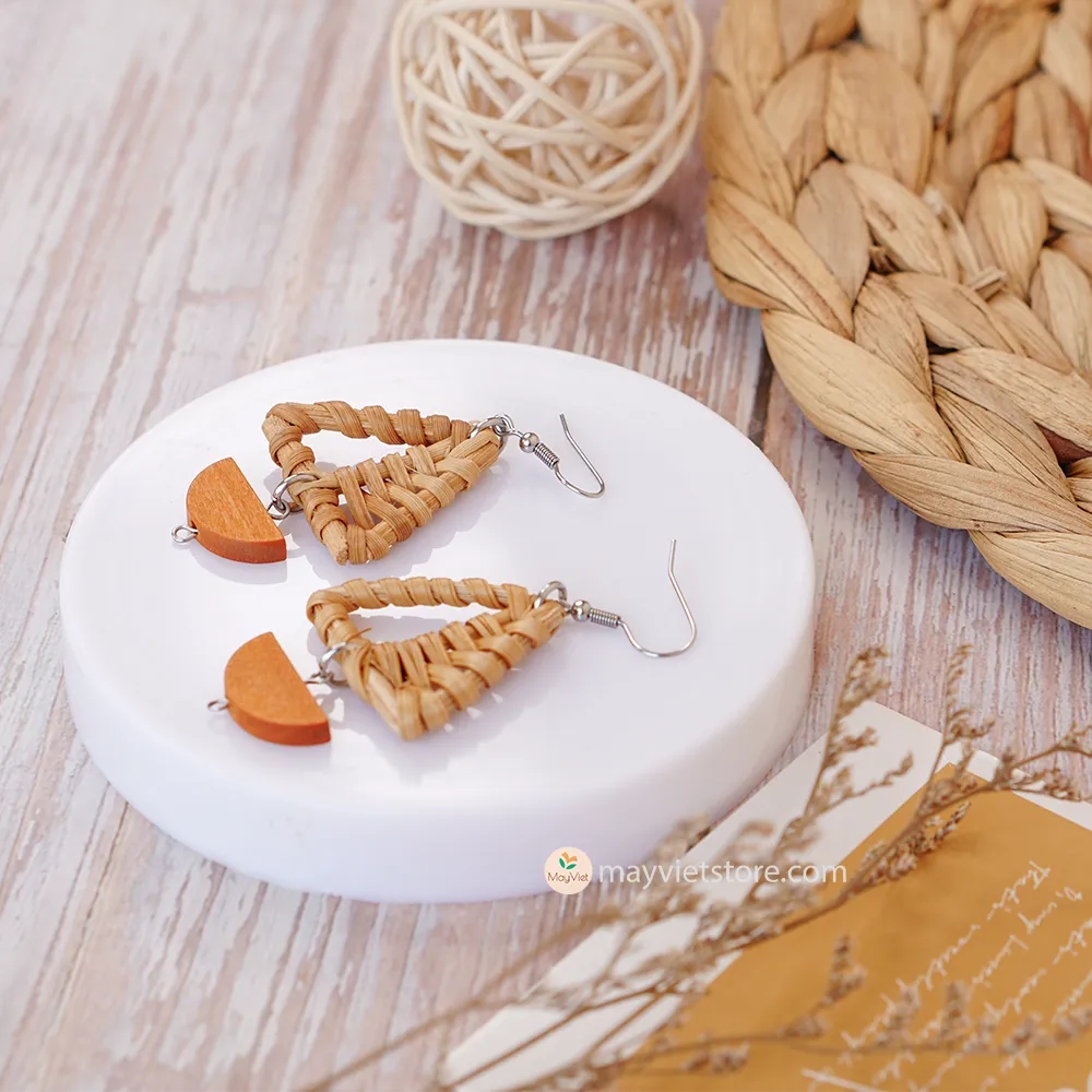 A pair of handcrafted rattan earrings with mini triangular brown wooden beads, made by Mayvietstore. The earrings are made of high-quality rattan and wood, and are lightweight and comfortable to wear. The mini triangular beads add a touch of delicate and minimalist style to the earrings, and the brown wooden beads give them a warm and natural look. These earrings are perfect for any occasion, from a casual day out to a special event.