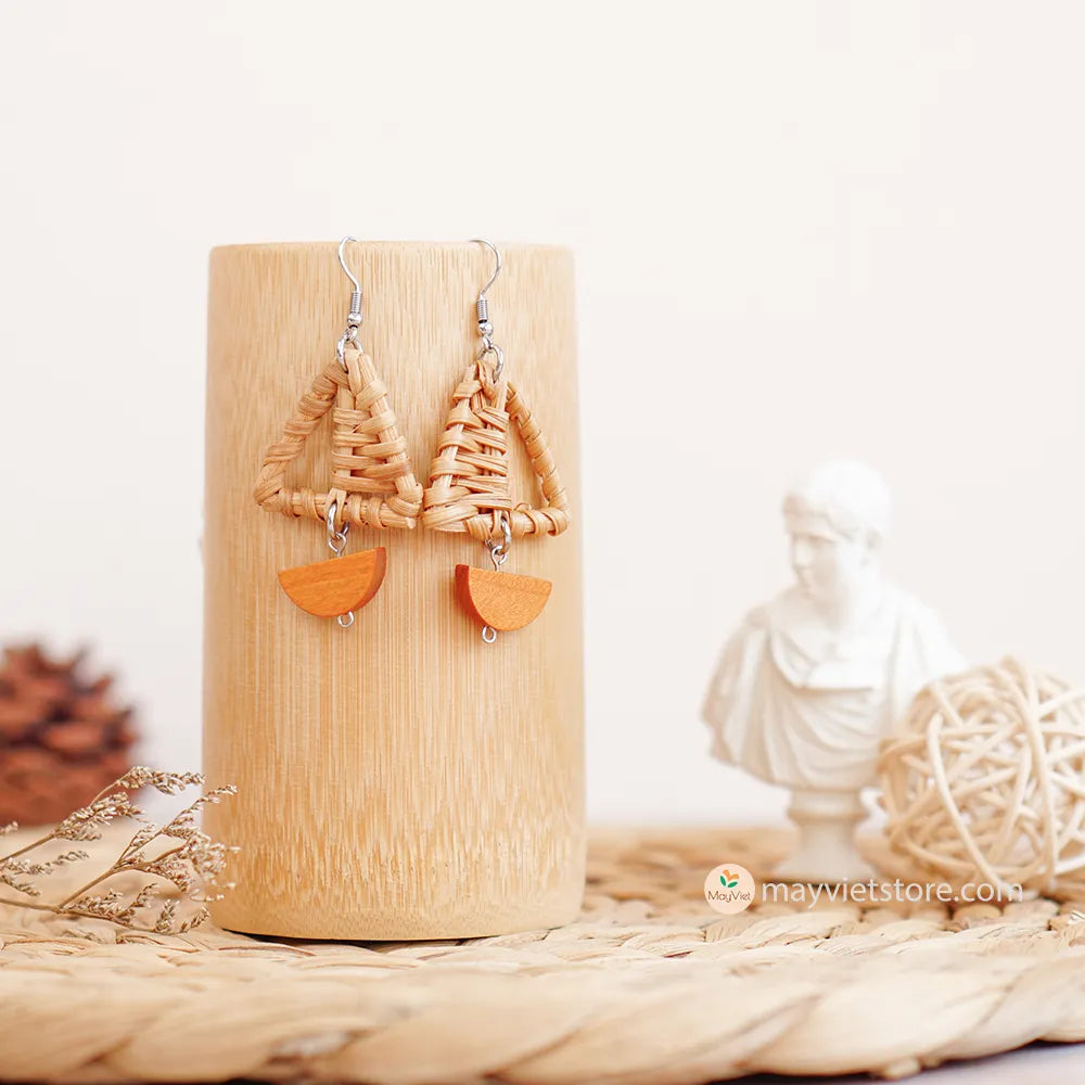 A pair of handcrafted rattan earrings with mini triangular brown wooden beads, made by Mayvietstore. The earrings are made of high-quality rattan and wood, and are lightweight and comfortable to wear. The mini triangular beads add a touch of delicate and minimalist style to the earrings, and the brown wooden beads give them a warm and natural look. These earrings are perfect for any occasion, from a casual day out to a special event.