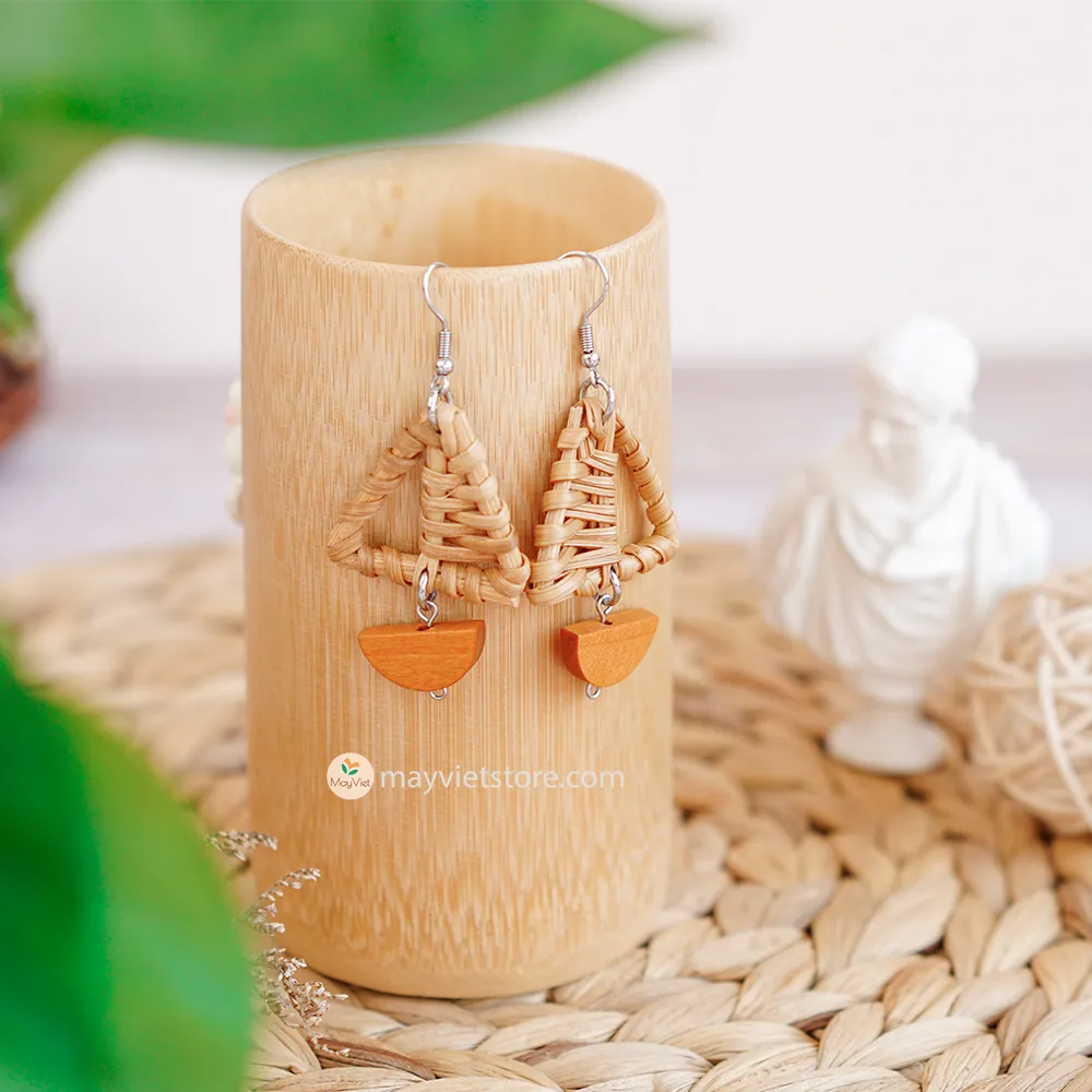 A pair of handcrafted rattan earrings with mini triangular brown wooden beads, made by Mayvietstore. The earrings are made of high-quality rattan and wood, and are lightweight and comfortable to wear. The mini triangular beads add a touch of delicate and minimalist style to the earrings, and the brown wooden beads give them a warm and natural look. These earrings are perfect for any occasion, from a casual day out to a special event.