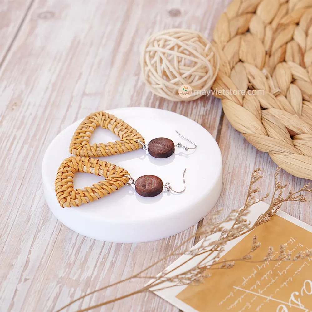 A pair of handcrafted rattan earrings with triangular brown wooden beads, made by Mayvietstore. The earrings are made of high-quality rattan and wood, and are lightweight and comfortable to wear. The triangular beads add a touch of geometric interest to the earrings, and the brown wooden beads give them a warm and natural look. These earrings are perfect for any occasion, from a casual day out to a special event.