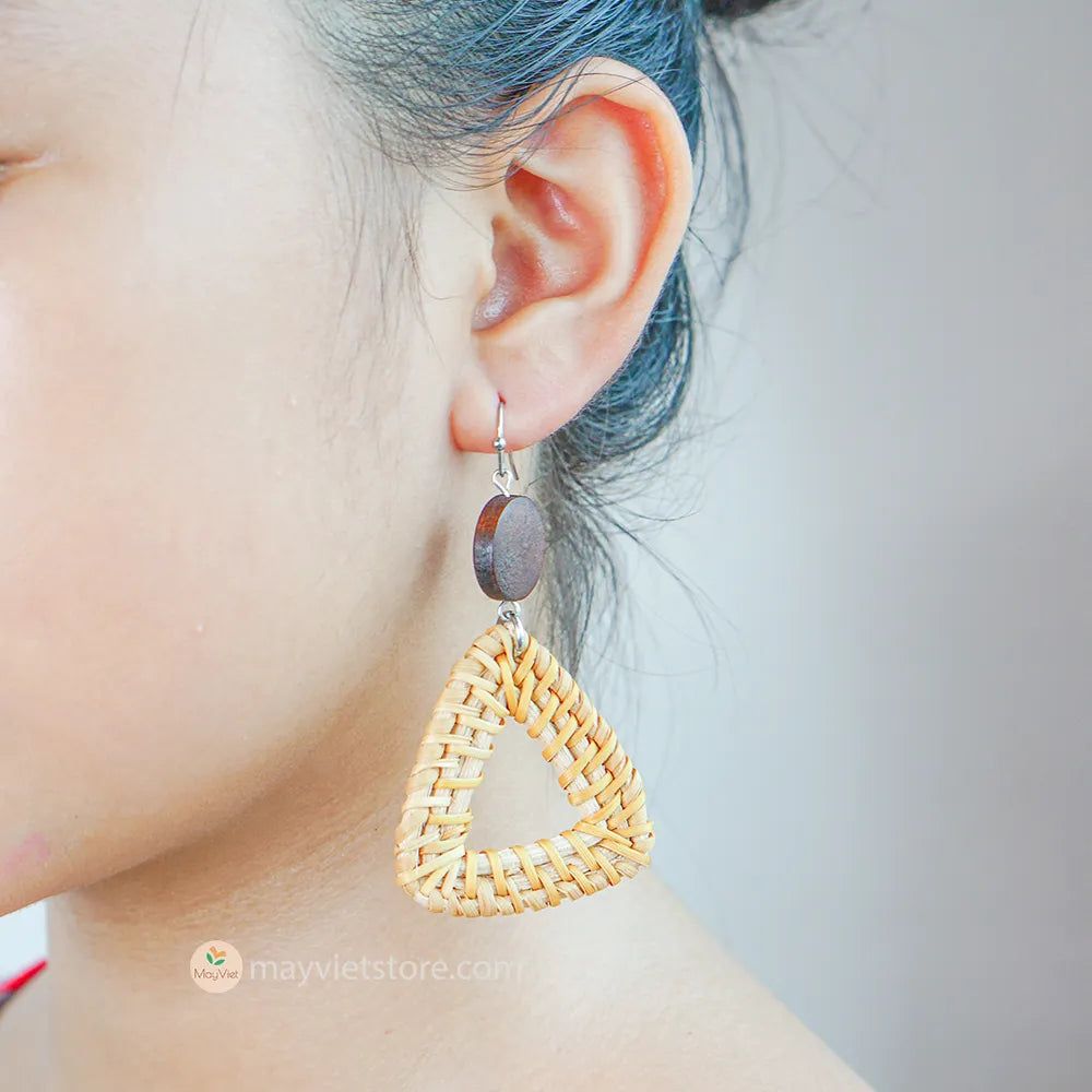 A pair of handcrafted rattan earrings with triangular brown wooden beads, made by Mayvietstore. The earrings are made of high-quality rattan and wood, and are lightweight and comfortable to wear. The triangular beads add a touch of geometric interest to the earrings, and the brown wooden beads give them a warm and natural look. These earrings are perfect for any occasion, from a casual day out to a special event.