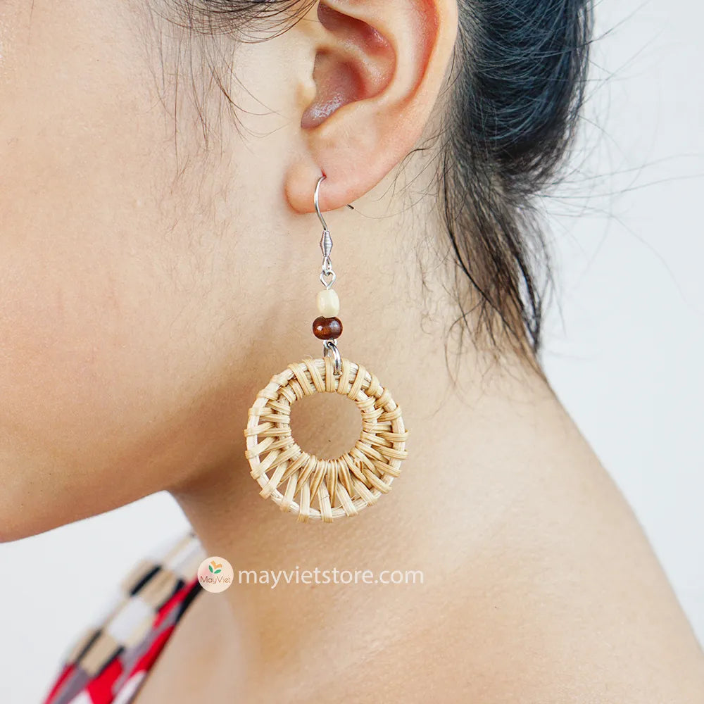 A pair of mini rattan round earrings with wooden beads, handcrafted by Mayvietstore. The earrings are made of high-quality rattan and wood, and are lightweight and comfortable to wear. They are perfect for everyday wear or for special occasions.