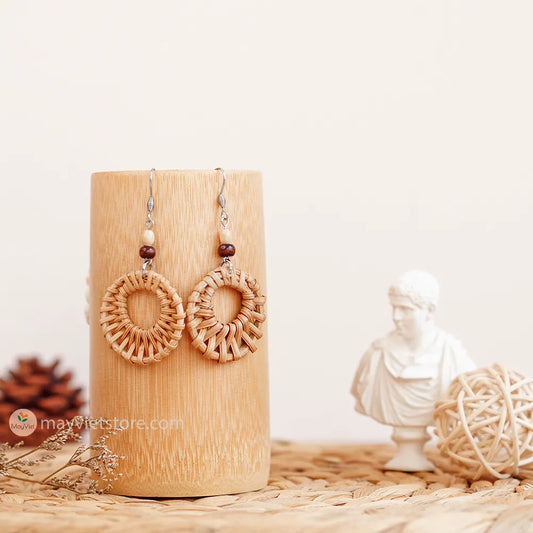 A pair of mini rattan round earrings with wooden beads, handcrafted by Mayvietstore. The earrings are made of high-quality rattan and wood, and are lightweight and comfortable to wear. They are perfect for everyday wear or for special occasions.