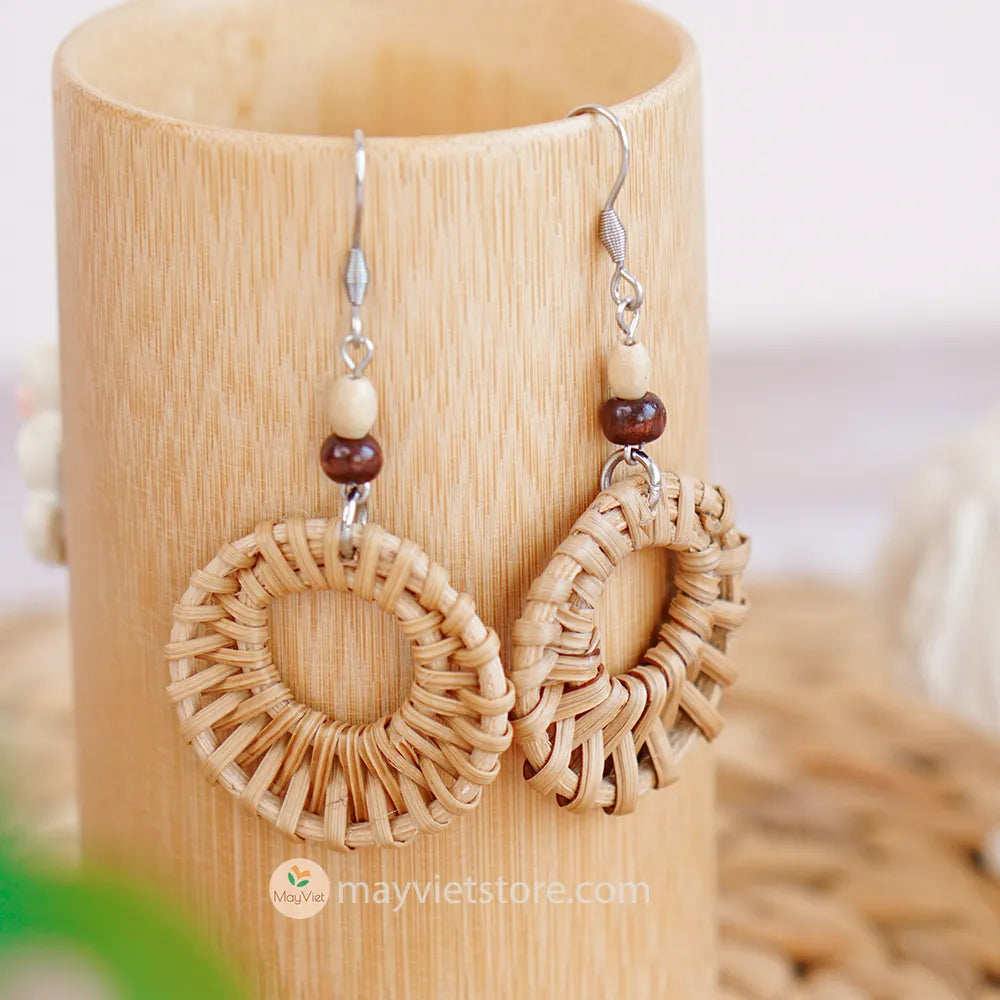 A pair of mini rattan round earrings with wooden beads, handcrafted by Mayvietstore. The earrings are made of high-quality rattan and wood, and are lightweight and comfortable to wear. They are perfect for everyday wear or for special occasions.