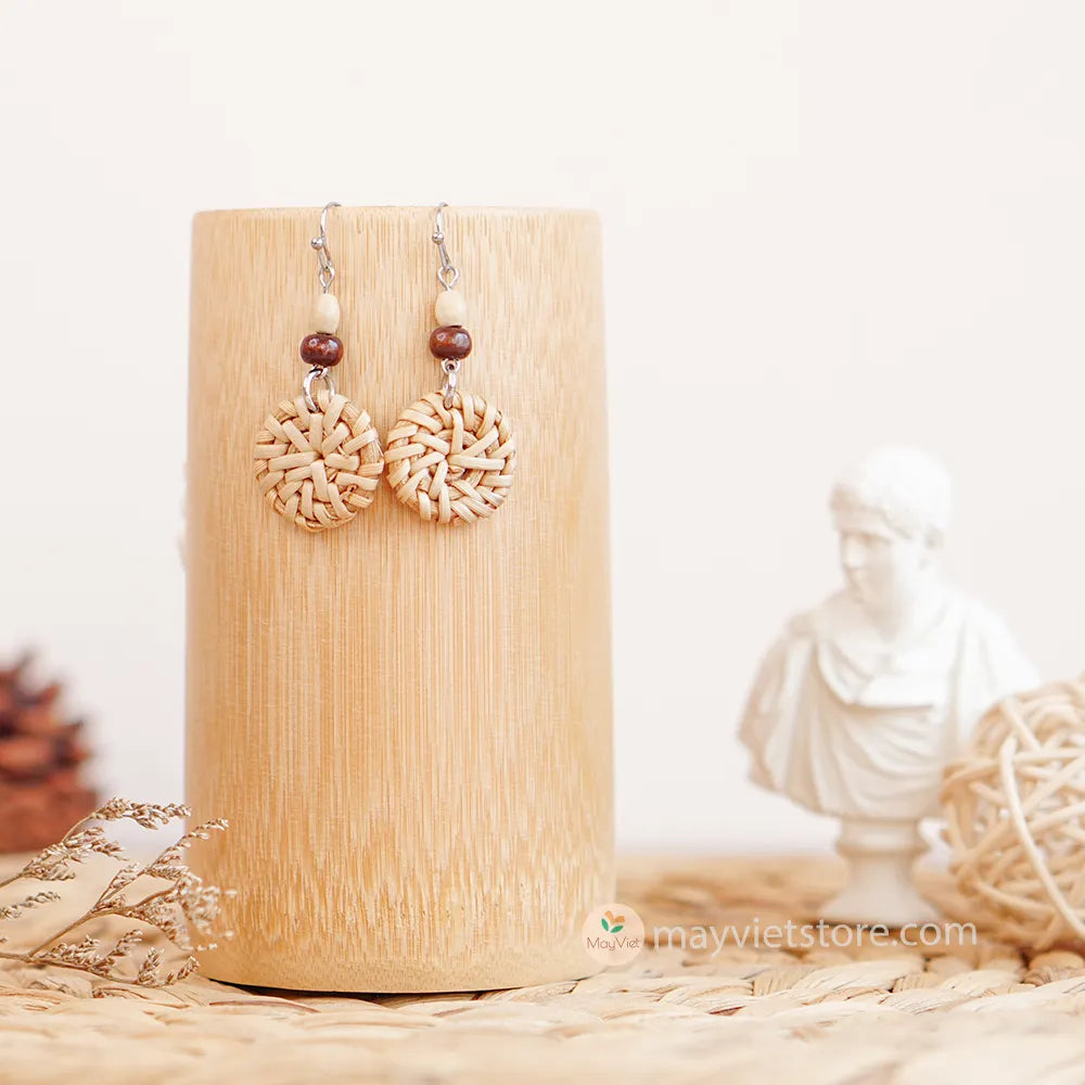 A pair of mini rattan round earrings with wooden beads, handcrafted by Mayvietstore. The earrings are made of high-quality rattan and wood, and are lightweight and comfortable to wear. They are perfect for everyday wear or for special occasions.