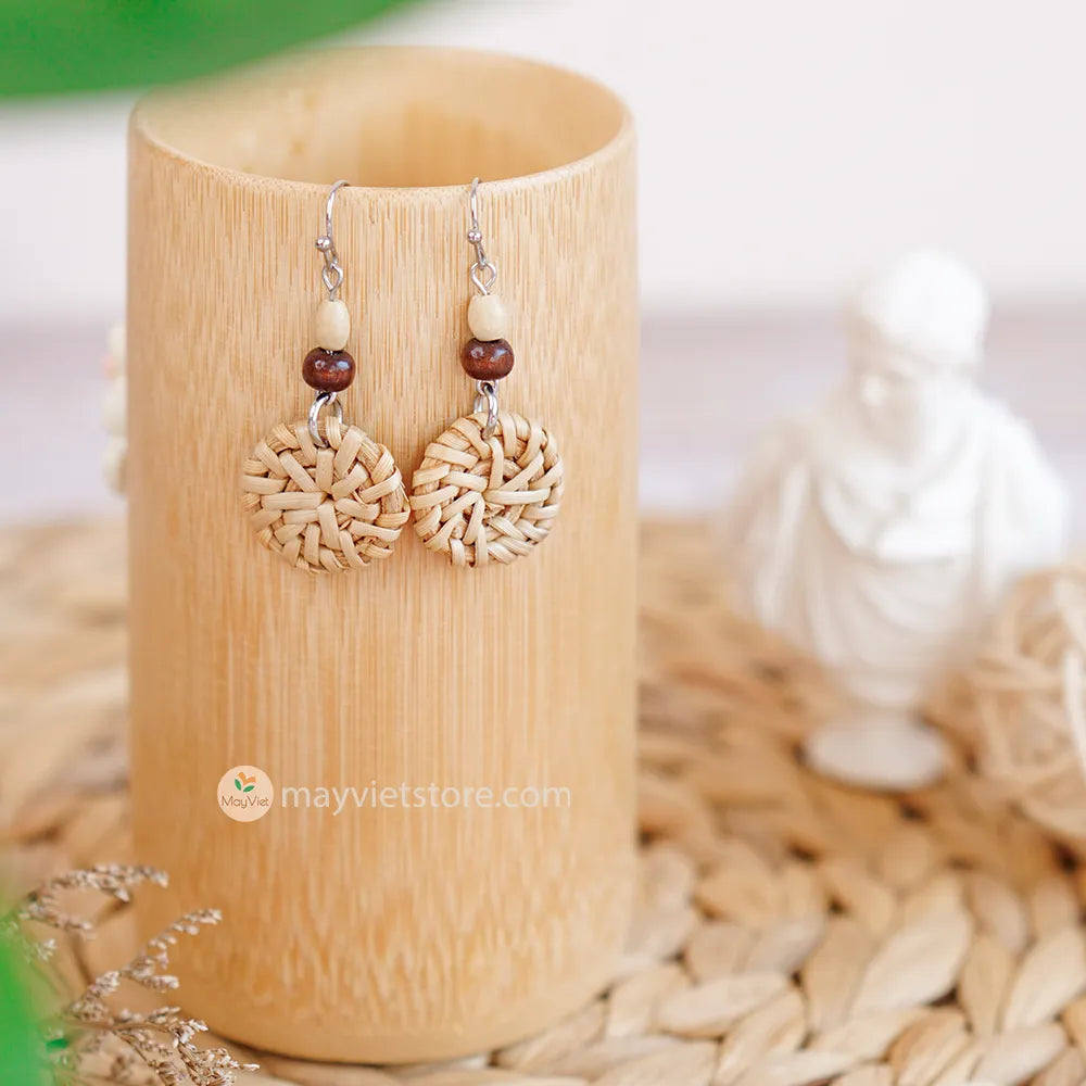 A pair of mini rattan round earrings with wooden beads, handcrafted by Mayvietstore. The earrings are made of high-quality rattan and wood, and are lightweight and comfortable to wear. They are perfect for everyday wear or for special occasions.