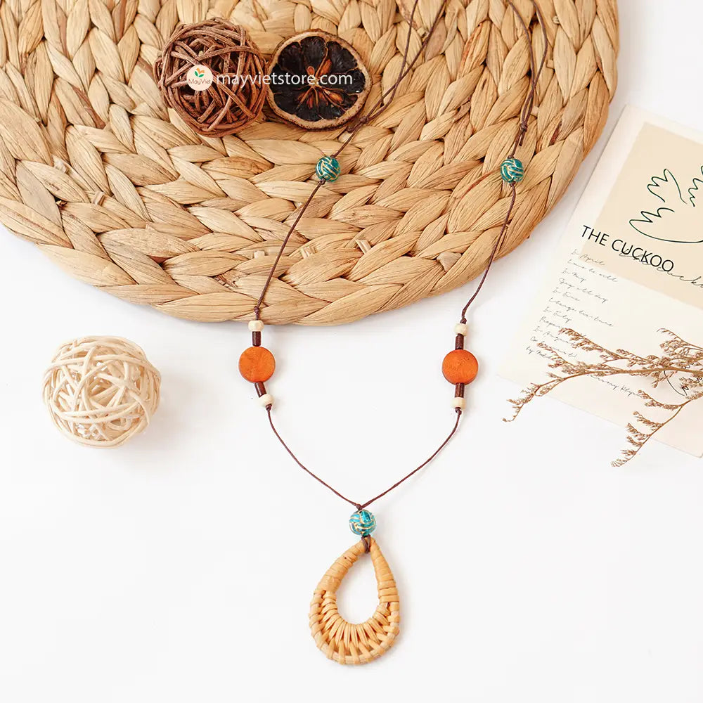The Mayvietstore Triangle Rattan Tassel Wooden Beads Necklace showcases a unique triangular rattan pendant with a tassel as its centerpiece. This rattan teardrop wooden beads necklace is a beautiful and elegant accessory. The rattan is lightweight and comfortable to wear, while the wooden beads add a touch of natural beauty. The teardrop shape is flattering and feminine, making this necklace perfect for any occasion.