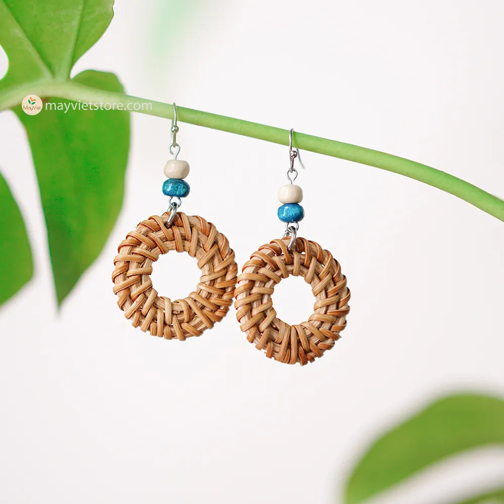 These round rattan hoop earrings with blue and white wooden beads are a fun and stylish accessory. The rattan is lightweight and comfortable to wear, while the blue and white wooden beads add a touch of nautical charm. The hoop shape is classic and versatile, making these earrings perfect for any occasion.