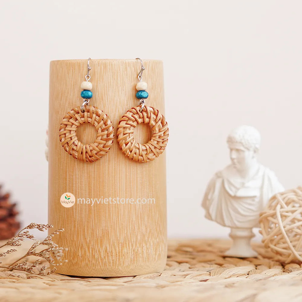 These round rattan hoop earrings with blue and white wooden beads are a fun and stylish accessory. The rattan is lightweight and comfortable to wear, while the blue and white wooden beads add a touch of nautical charm. The hoop shape is classic and versatile, making these earrings perfect for any occasion.