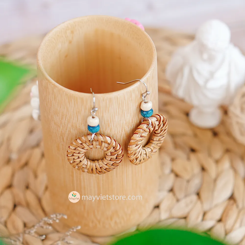 These round rattan hoop earrings with blue and white wooden beads are a fun and stylish accessory. The rattan is lightweight and comfortable to wear, while the blue and white wooden beads add a touch of nautical charm. The hoop shape is classic and versatile, making these earrings perfect for any occasion.