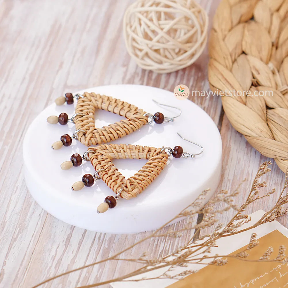 These triangle rattan earrings with brown wooden beads are a stylish and unique accessory. The rattan is lightweight and comfortable to wear, while the brown wooden beads add a touch of natural beauty. The triangle shape is geometric and modern, making these earrings perfect for any occasion.