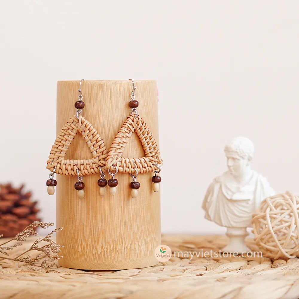 These triangle rattan earrings with brown wooden beads are a stylish and unique accessory. The rattan is lightweight and comfortable to wear, while the brown wooden beads add a touch of natural beauty. The triangle shape is geometric and modern, making these earrings perfect for any occasion.