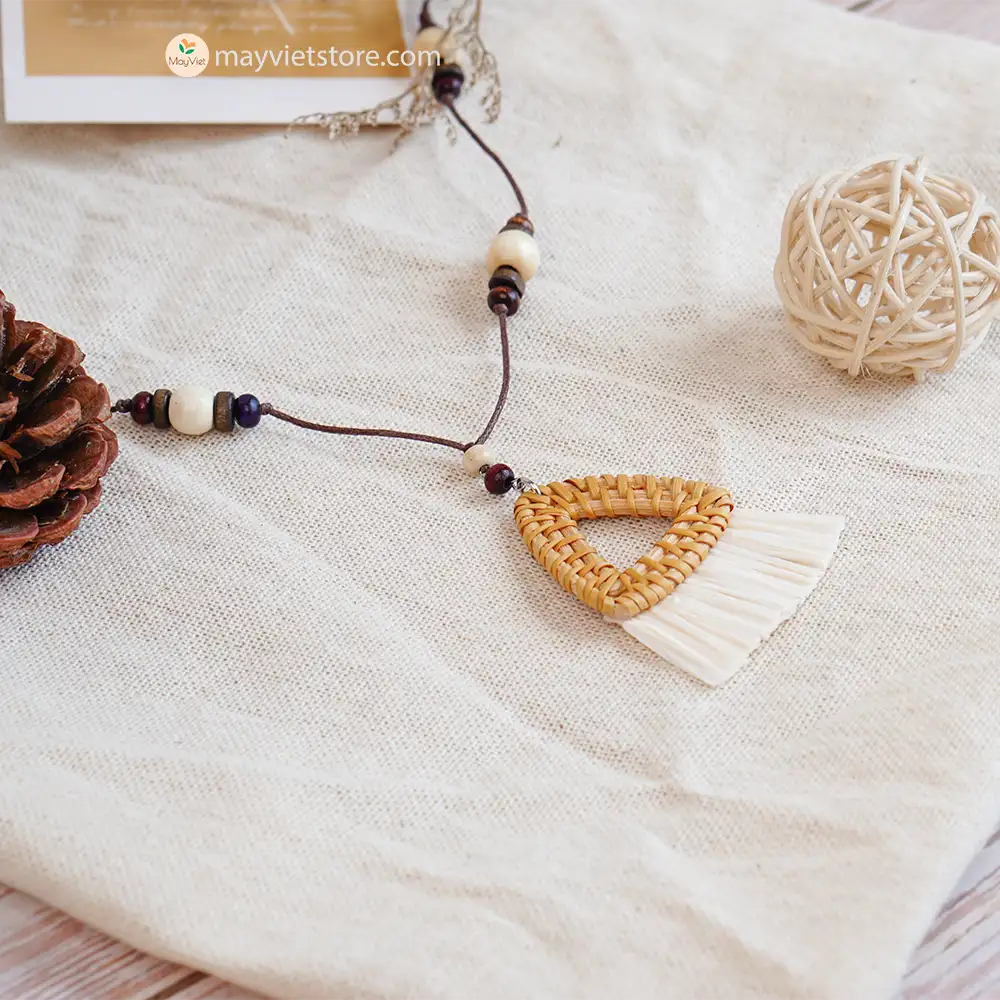 This triangle rattan tassel wooden beads necklace is a unique and stylish accessory. The rattan is lightweight and comfortable to wear, while the wooden beads add a touch of natural beauty. The triangle shape is geometric and modern, while the tassel adds a touch of fun and whimsy. This necklace is perfect for any occasion, from a casual day out to a special event.