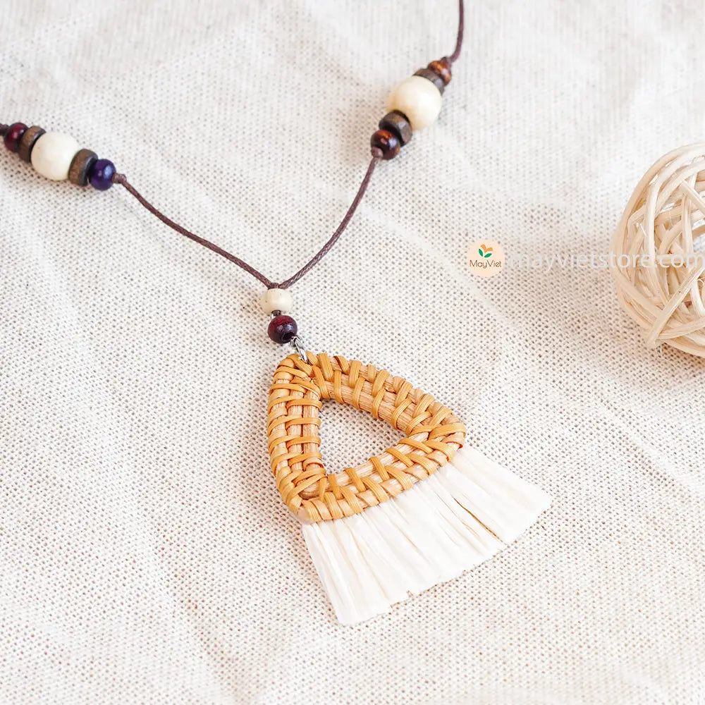This triangle rattan tassel wooden beads necklace is a unique and stylish accessory. The rattan is lightweight and comfortable to wear, while the wooden beads add a touch of natural beauty. The triangle shape is geometric and modern, while the tassel adds a touch of fun and whimsy. This necklace is perfect for any occasion, from a casual day out to a special event.