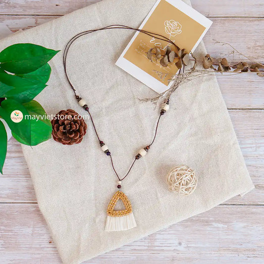 This triangle rattan tassel wooden beads necklace is a unique and stylish accessory. The rattan is lightweight and comfortable to wear, while the wooden beads add a touch of natural beauty. The triangle shape is geometric and modern, while the tassel adds a touch of fun and whimsy. This necklace is perfect for any occasion, from a casual day out to a special event.