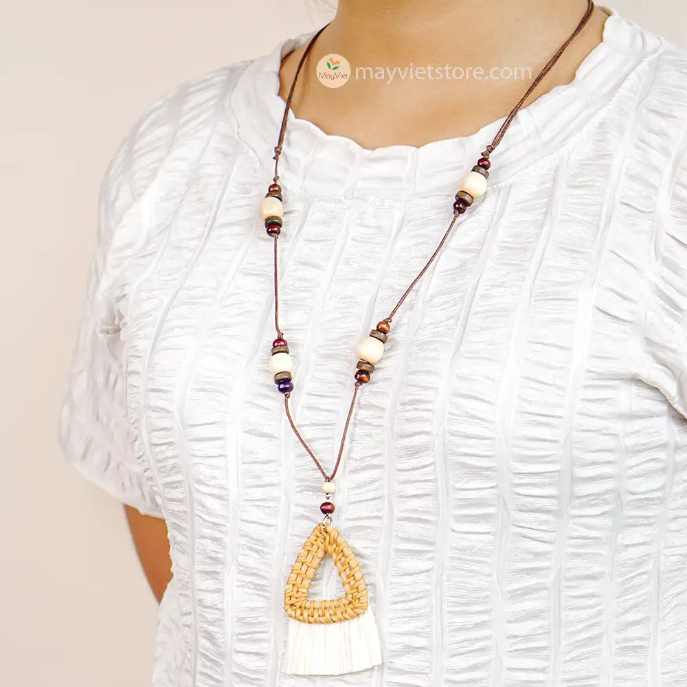 This triangle rattan tassel wooden beads necklace is a unique and stylish accessory. The rattan is lightweight and comfortable to wear, while the wooden beads add a touch of natural beauty. The triangle shape is geometric and modern, while the tassel adds a touch of fun and whimsy. This necklace is perfect for any occasion, from a casual day out to a special event.