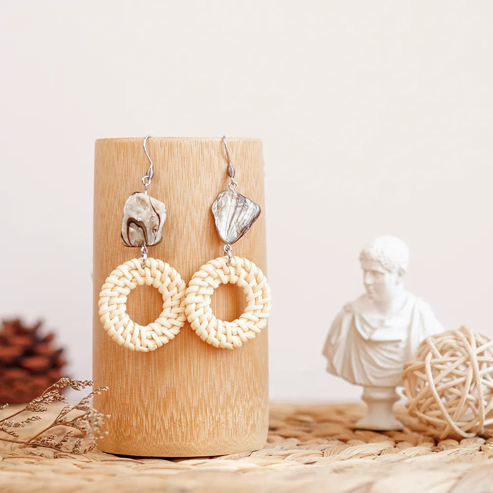 These white rattan hoop earrings with stripe stone beads are a unique and stylish accessory. The rattan is lightweight and comfortable to wear, while the stripe stone beads add a touch of sophistication and shine. The hoop shape is classic and versatile, making these earrings perfect for any occasion.